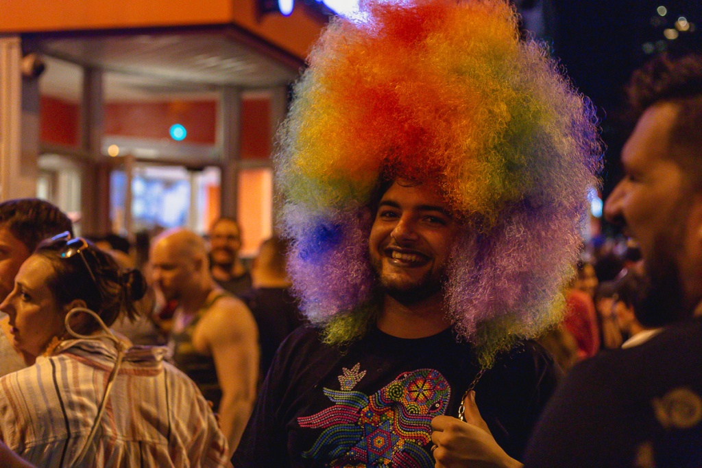 A man wearing a rainbow afro wig giving a thumbs up. © Andy Lee, 2022. realandylee.com